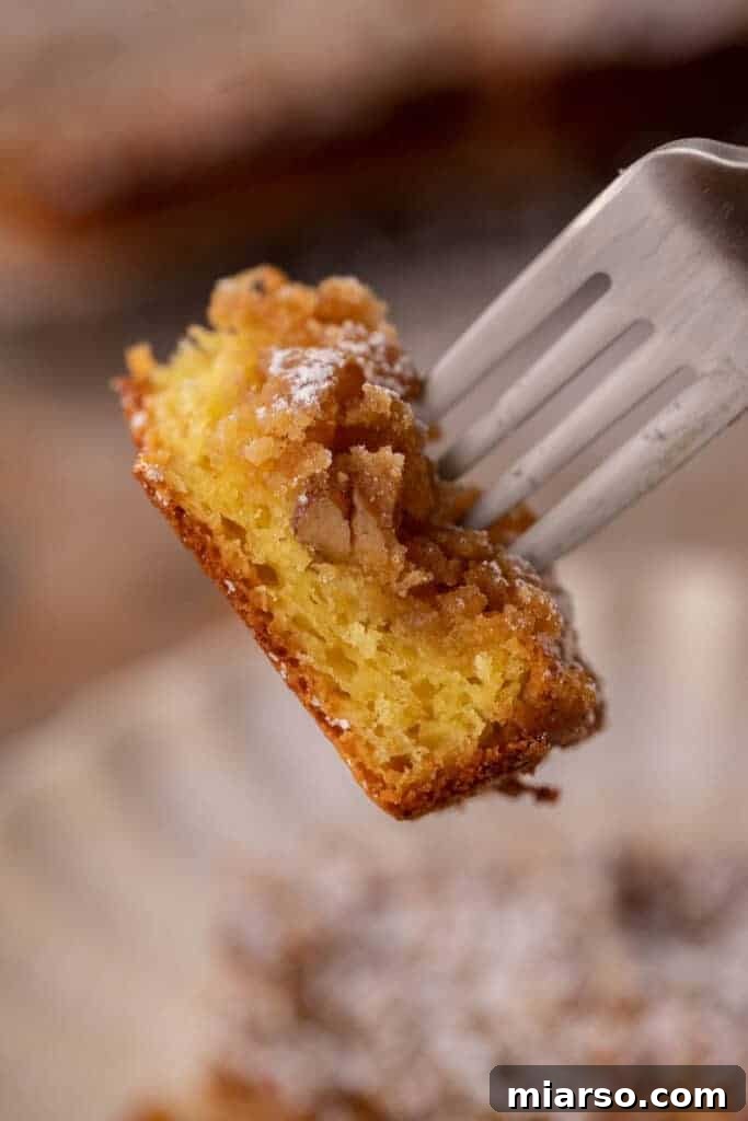 Close-up of a piece of yellow cake mix coffee cake on a fork, showing the streusel topping