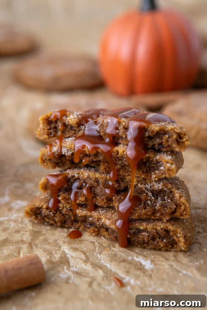 Stacked Brown Butter Pumpkin Snickerdoodle Cookies with a bite taken out, showing the soft interior