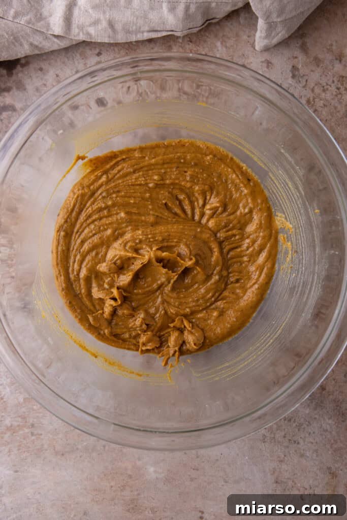 Dry ingredients being added to wet ingredients for cookie dough