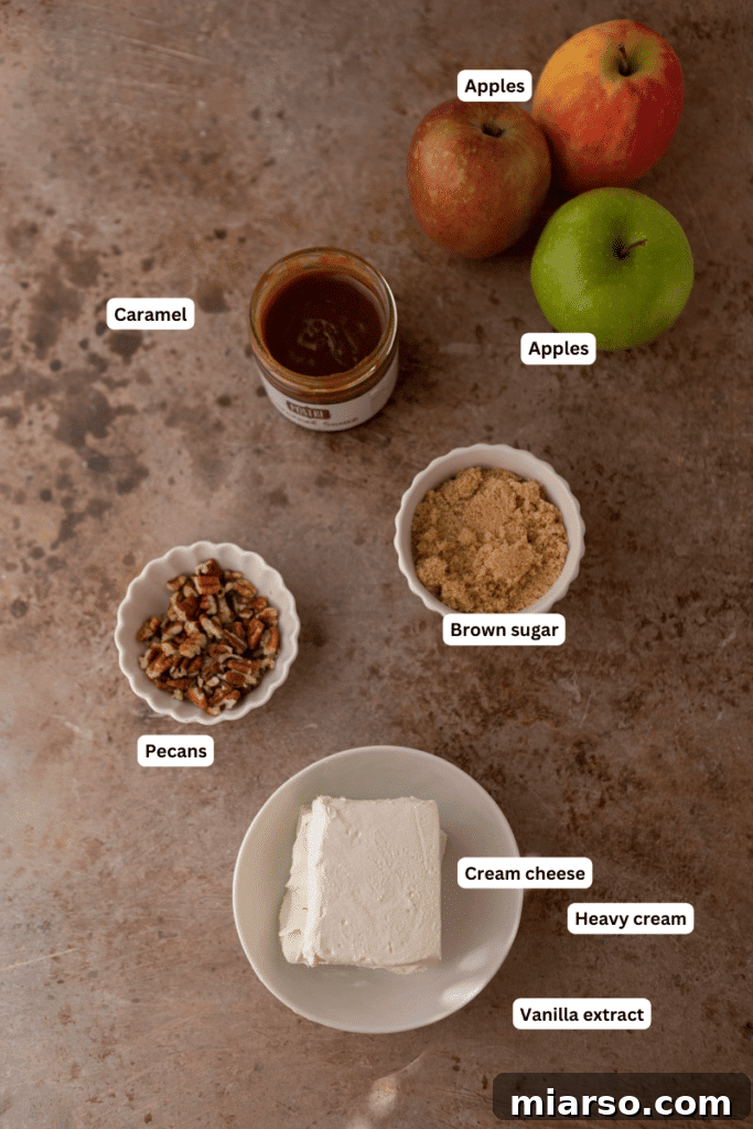 Various ingredients for the caramel apple cheesecake dip laid out on a kitchen counter, showcasing freshness and quality.