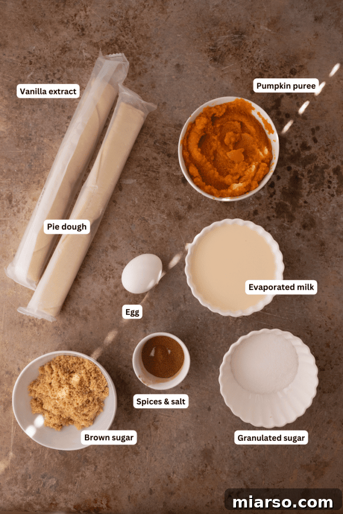 Bite-Sized Pumpkin Delights in a Muffin Tin 3 Ingredients for mini pumpkin pies laid out on a wooden table, including pumpkin puree, spices, evaporated milk, and pie crust.