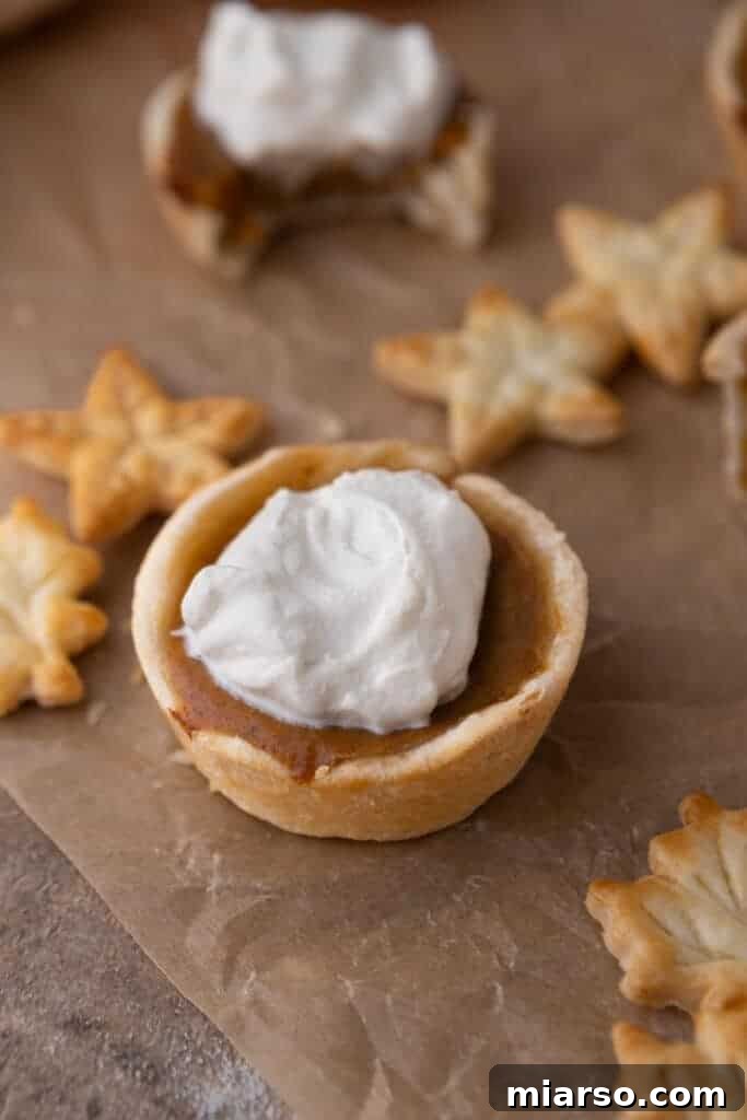 Bite-Sized Pumpkin Delights in a Muffin Tin 4 Diagonal overhead shot of a whole mini pumpkin pie, perfectly baked with a golden crust and smooth, set filling.