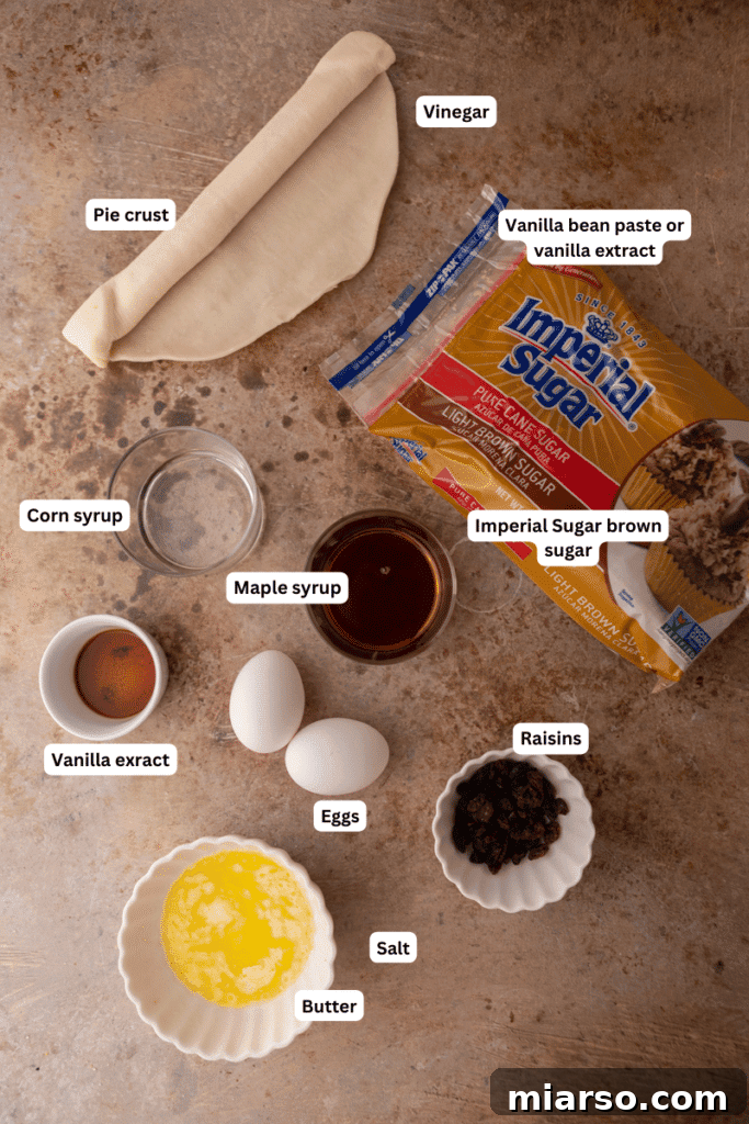 An array of fresh baking ingredients including butter, brown sugar, eggs, vanilla, and corn syrup neatly arranged on a kitchen counter, ready for making butter tarts