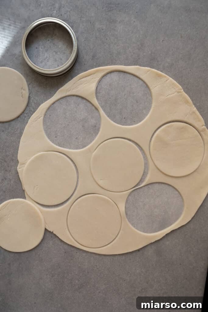 Pie crust rounds on a lightly floured work surface, ready to be placed in a muffin tin