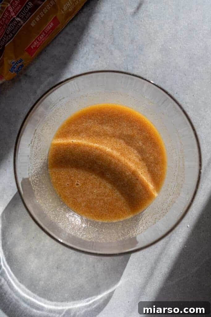 Smooth, golden-brown butter tart filling in a bowl, ready to be poured into tart shells