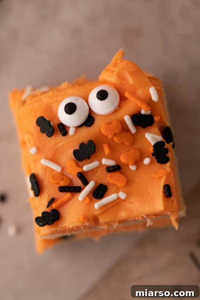 Spooktacularly Simple Halloween Sugar Cookie Bars 4 Overhead shot of spooky Halloween sugar cookie bars topped with orange frosting and sprinkles