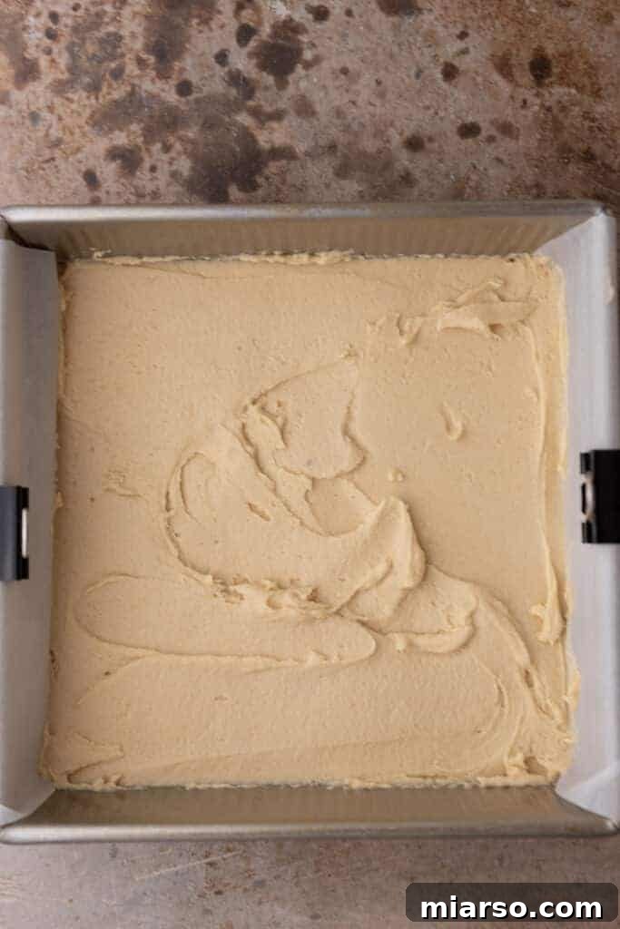 Spooktacularly Simple Halloween Sugar Cookie Bars 7 Cookie dough spread evenly on a baking pan lined with parchment paper