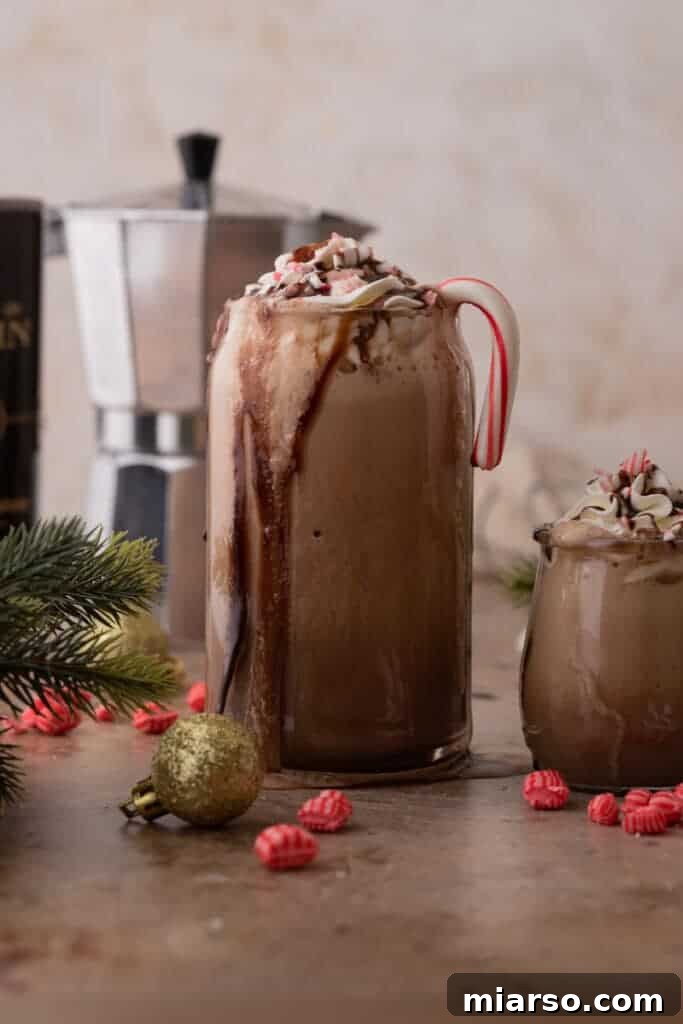 Copycat Starbucks Peppermint Mocha Frappuccino Recipe, served in a glass with whipped cream and crushed candy canes.