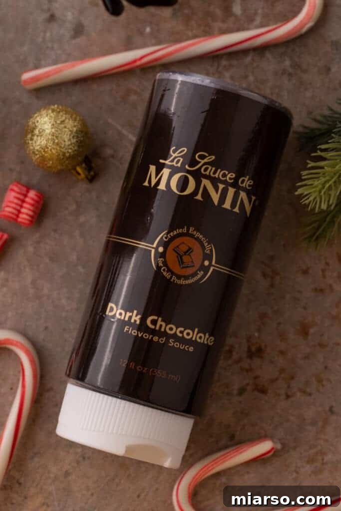 A bottle of Monin dark chocolate syrup, a key ingredient for rich chocolate flavor.