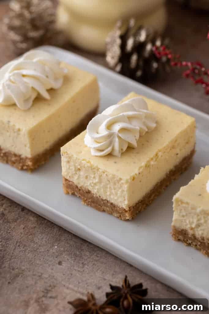 Decadent eggnog cheesecake bars arranged on a serving plate, dusted with nutmeg