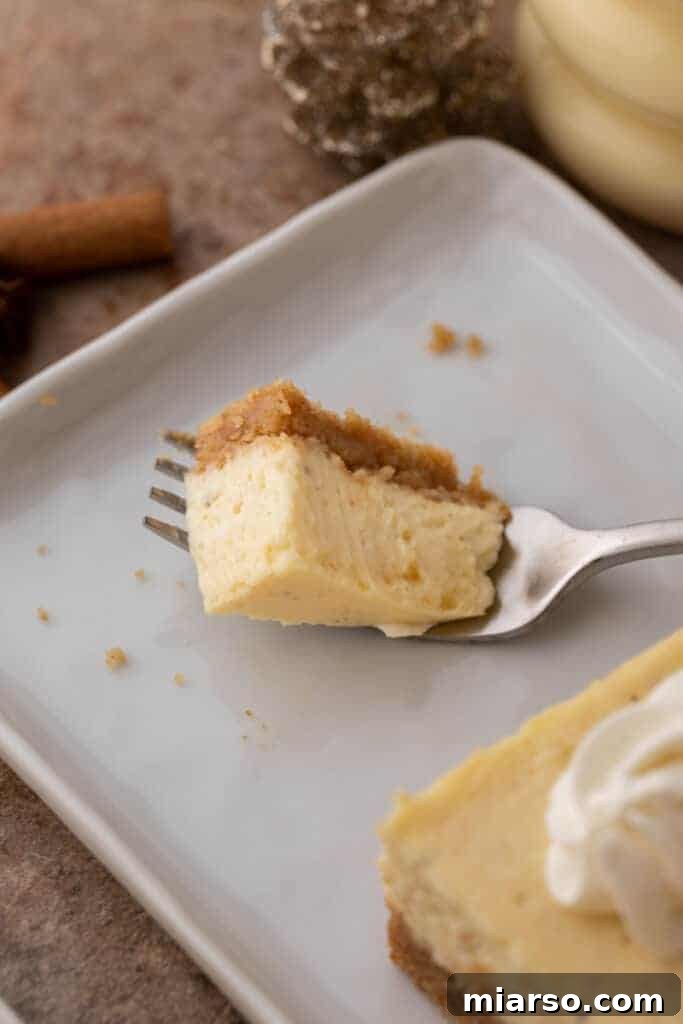 A slice of eggnog cheesecake on a fork, showing its creamy texture