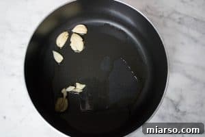 sautéing garlic to infuse the olive oil with flavor for the marinara sauce