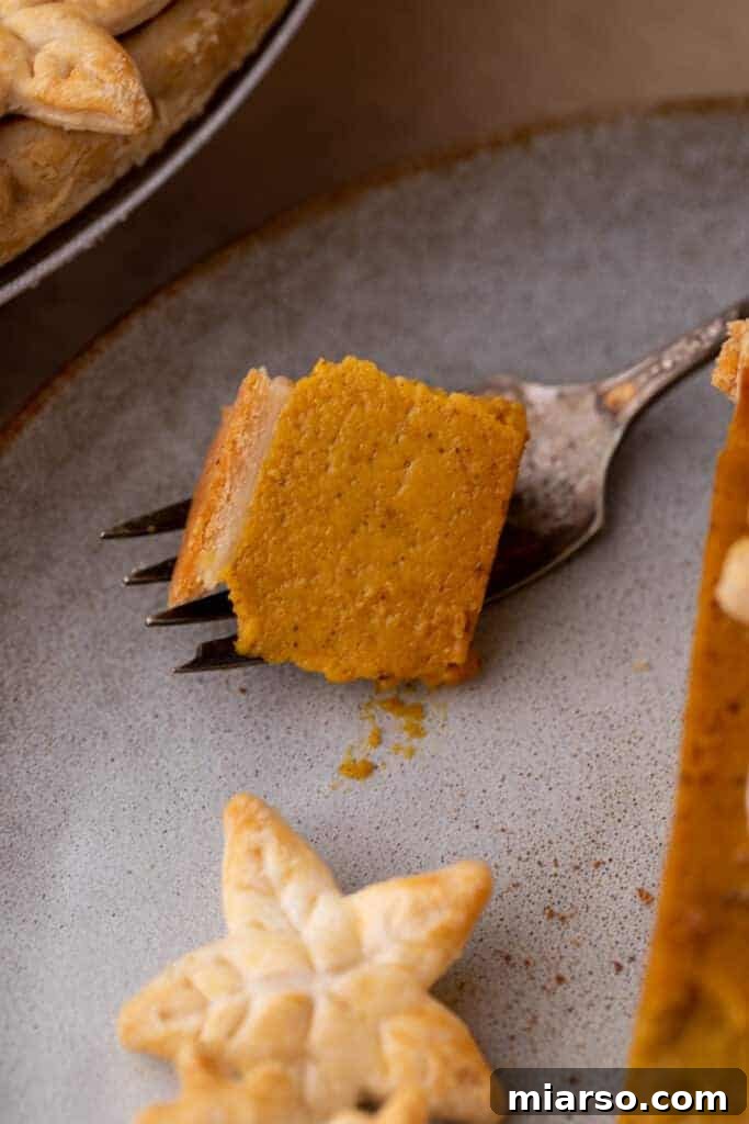 Double the Delight: The Ultimate 9-Inch Pumpkin Pie Recipe 12 A close-up of a fork holding a delicious bite of pumpkin pie, showcasing its smooth texture and rich color.