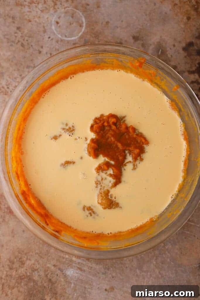 Double the Delight: The Ultimate 9-Inch Pumpkin Pie Recipe 8 The complete, unbaked pumpkin pie filling in a mixing bowl, showcasing its smooth, creamy texture and rich color.