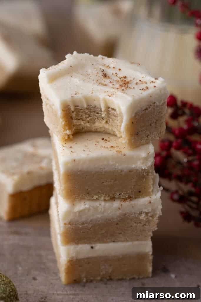 Stacked eggnog cookie bars with frosting and a sprinkle of nutmeg