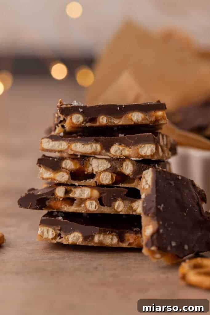 A delectable stack of Chocolate Caramel Pretzel Crack pieces, showcasing layers of crunchy pretzels, golden caramel, and smooth, melted chocolate.
