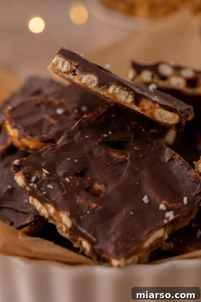 Close-up of numerous Christmas treat pieces neatly stacked in a decorative dish, garnished with a sprinkle of sea salt on top for a delightful contrast.