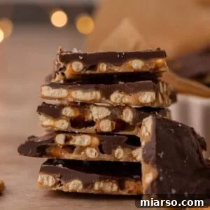 Stack of chocolate caramel pretzel crack pieces with visible pretzels and chocolate layers.