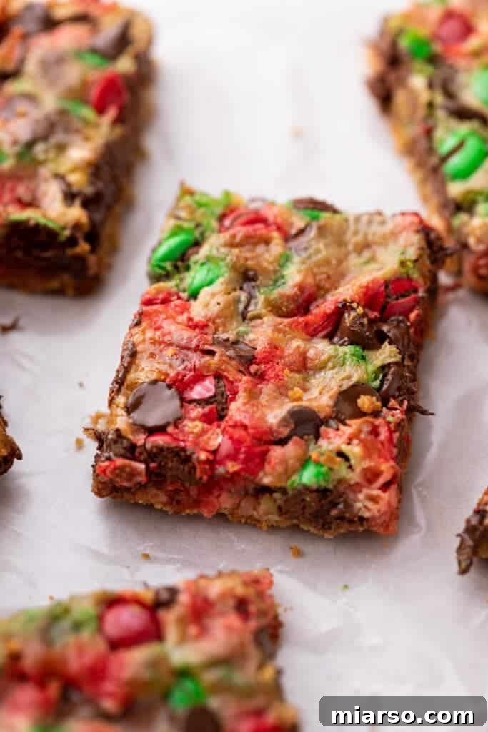 Close up of a Christmas magic cookie bar, showcasing its rich, layered texture and festive appeal