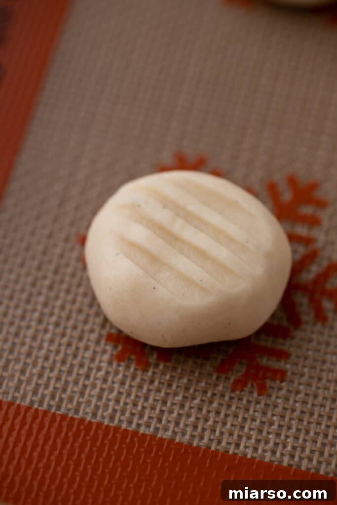 close up of raw cookie dough with a marking from a fork pressed on top