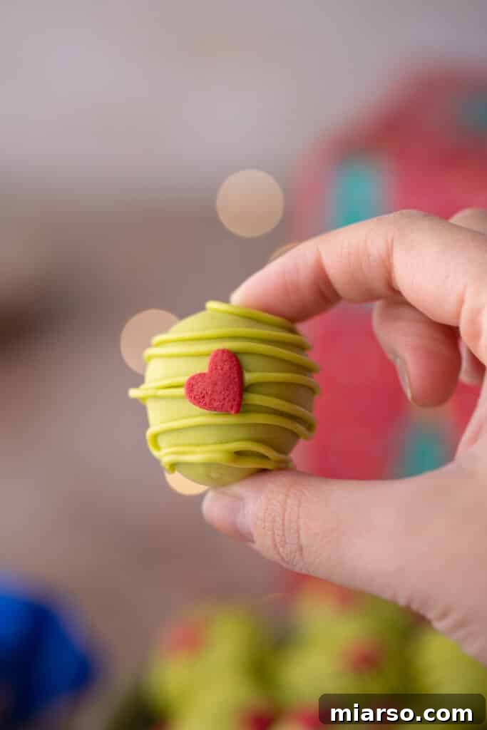 a single oreo ball being held in the air by a hand