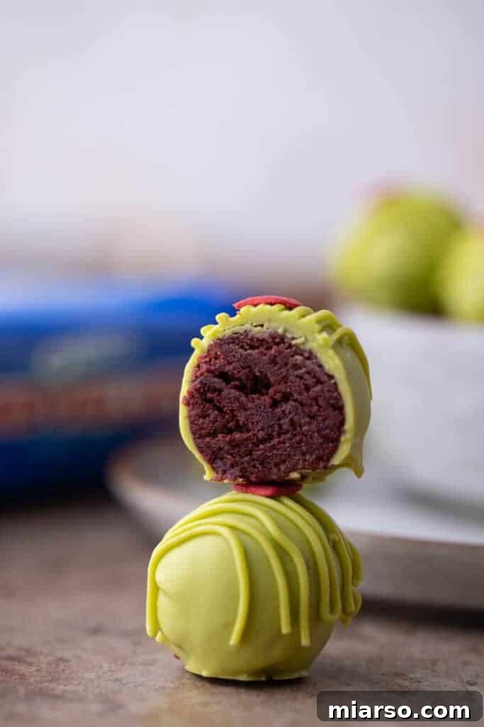 a grinch oreo truffle split in half, on top of a whole one