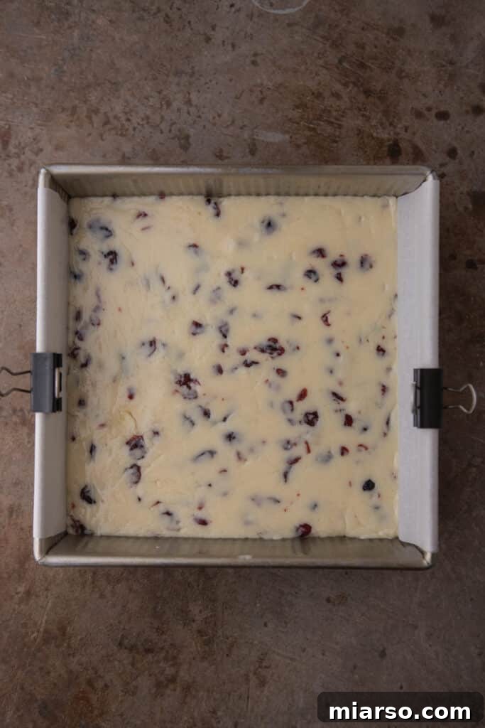 The freshly prepared fudge mixture spread evenly in a square pan, ready for chilling.