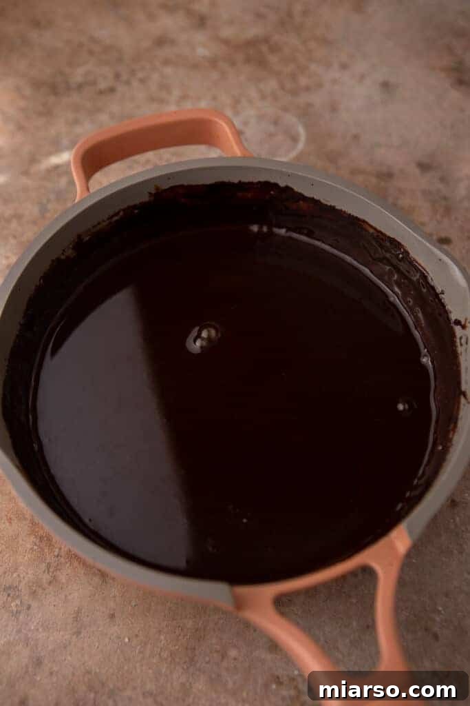 Ultimate Homemade Mocha Coffee Syrup 6 Finished mocha coffee syrup simmering gently in a saucepan, showcasing its liquid consistency.