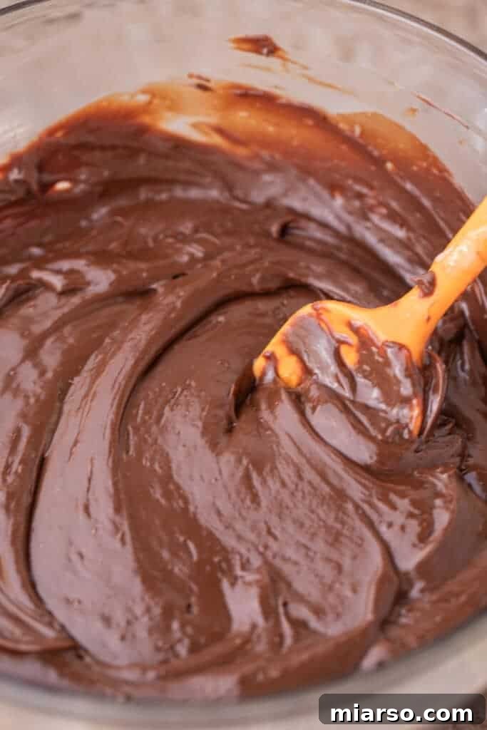 Peppermint fudge recipe ingredients being mixed together in a bowl, showing the smooth, melting process.