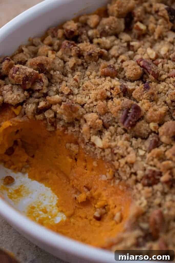 Pecan-Topped Sweet Potato Perfection 13 sweet potato casserole with pecan topping with a spoonful taken out