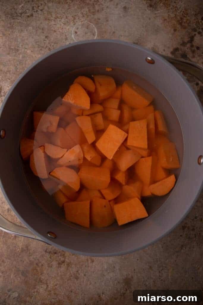 Pecan-Topped Sweet Potato Perfection 5 raw potato boiling in a pot of water