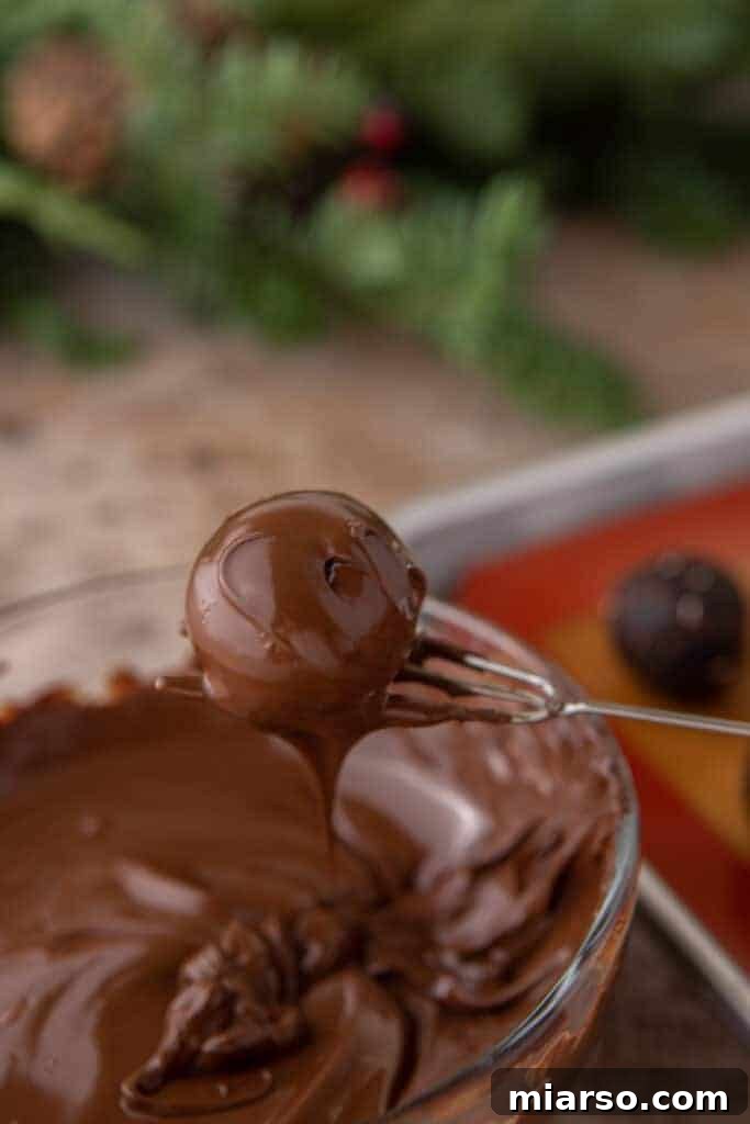 A ball being held up by a chocolate dipping fork