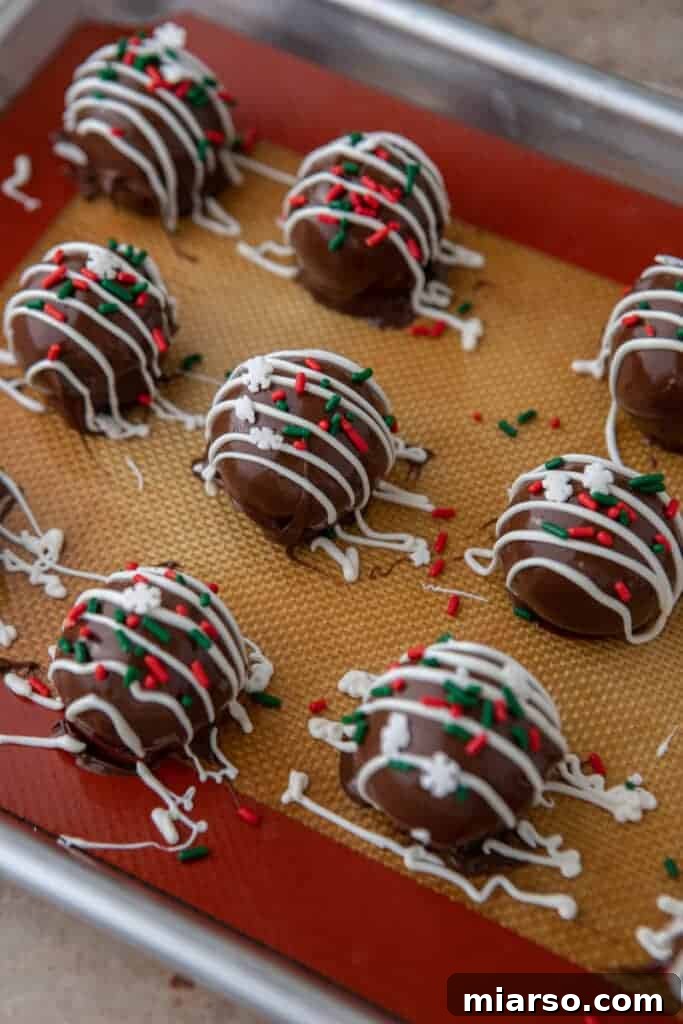Multiple finished Little Debbie Chocolate Christmas tree cakes truffles lined up on a baking sheet