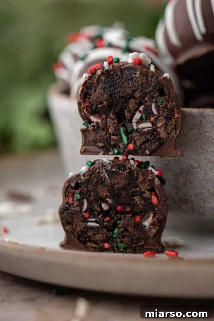 Close-up of two stacked cake truffle halves showing the fudgy center and festive sprinkles.