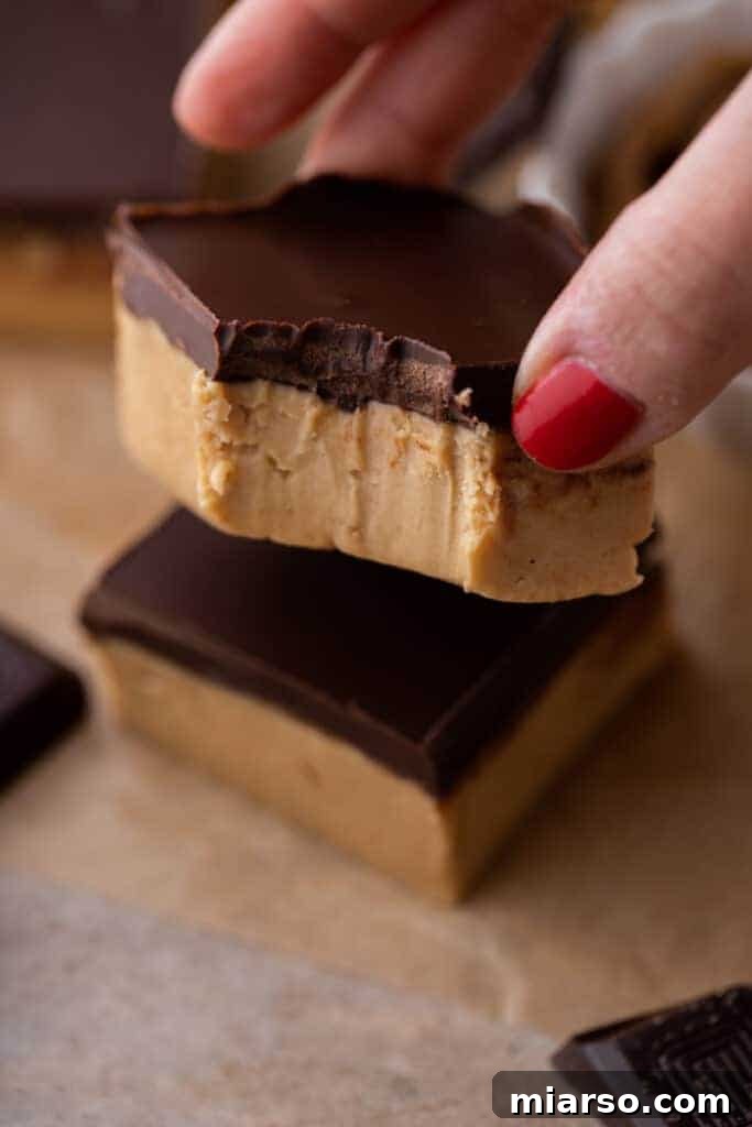 a square from the buckeye bars recipe with a bite take out of it being held up by a hand