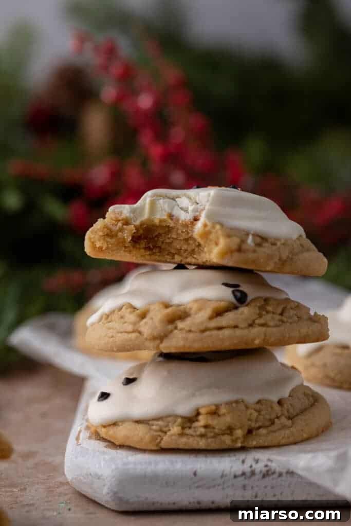 Three beautifully stacked melted snowman peanut butter cookies, showcasing their charming decorations.