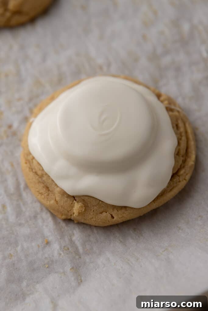 Melted white chocolate generously spread over the peanut butter cup and the top of the cookie, forming the 'melted' effect.