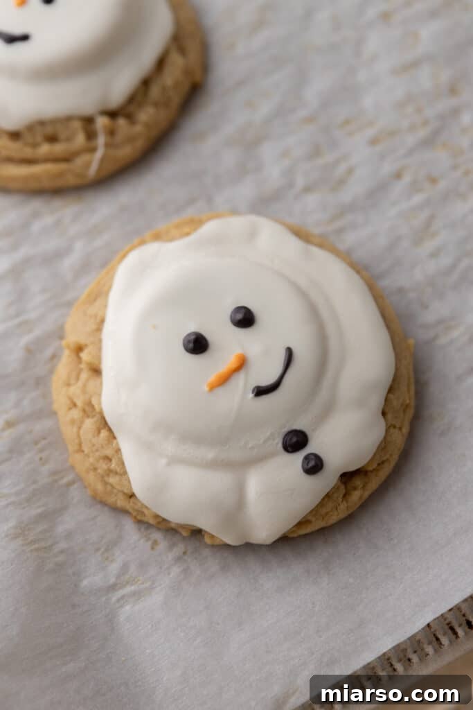 A fully baked and charmingly decorated melted snowman peanut butter cookie, ready to be enjoyed.