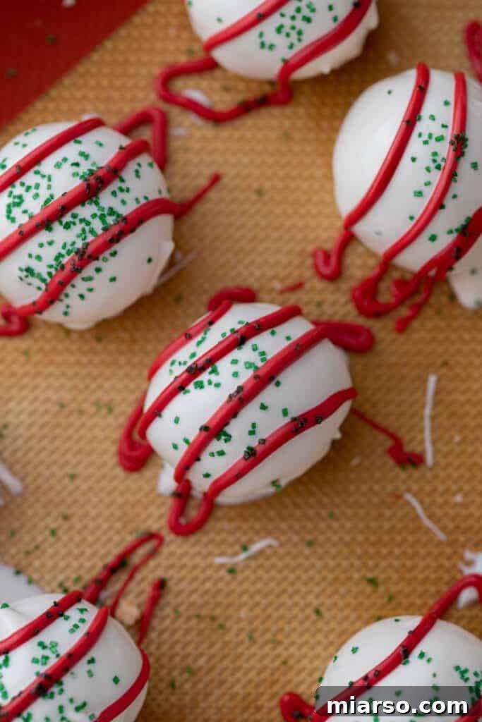 Easy No-Bake Little Debbie Christmas Tree Truffles 11 An overhead shot showcasing a platter of beautifully finished Little Debbie Christmas Tree Cake Truffles, adorned with red drizzle and green sanding sugar.