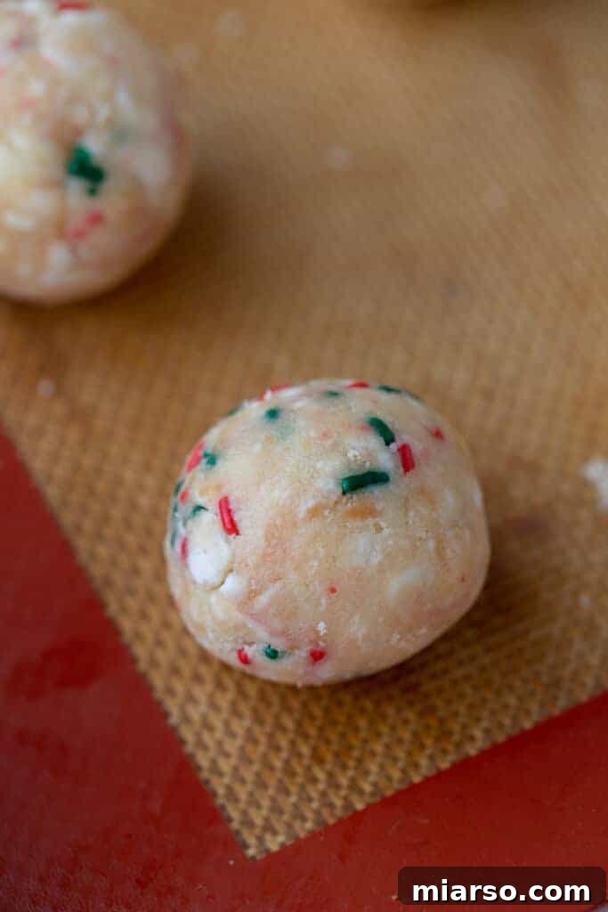 Easy No-Bake Little Debbie Christmas Tree Truffles 7 Small, perfectly rolled truffle balls arranged on a parchment-lined baking sheet, ready for chilling.