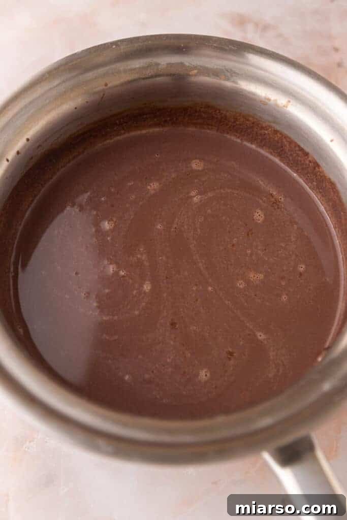 Fully heated and mixed hot chocolate ingredients in a pot, smooth and ready to pour.