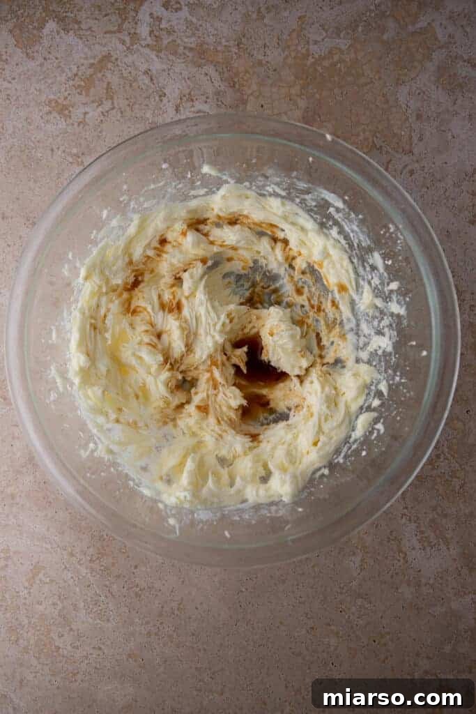 Creamed butter and sugar mixture with vanilla in a glass bowl.