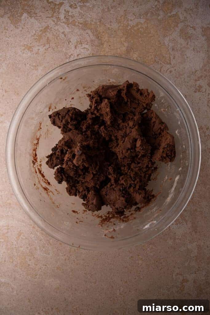 Chocolate cookie dough being rolled into balls.