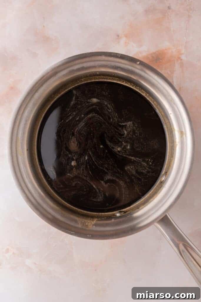 Brown sugar syrup ingredients simmering in a saucepan, showing the sugar dissolving.