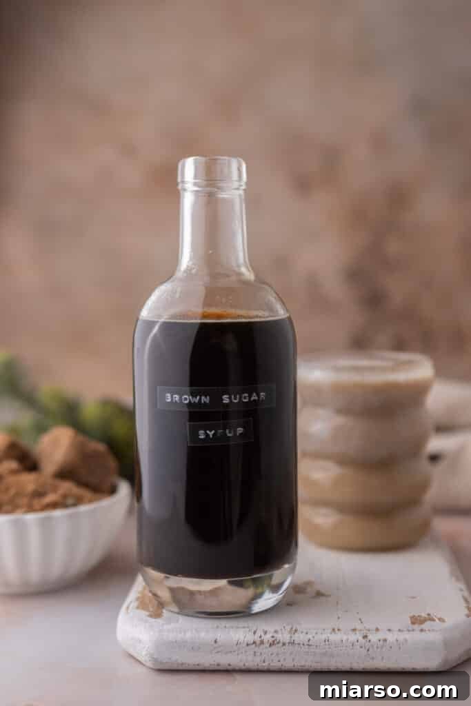 A jar of homemade Starbucks brown sugar syrup displayed prominently next to a finished cup of coffee.
