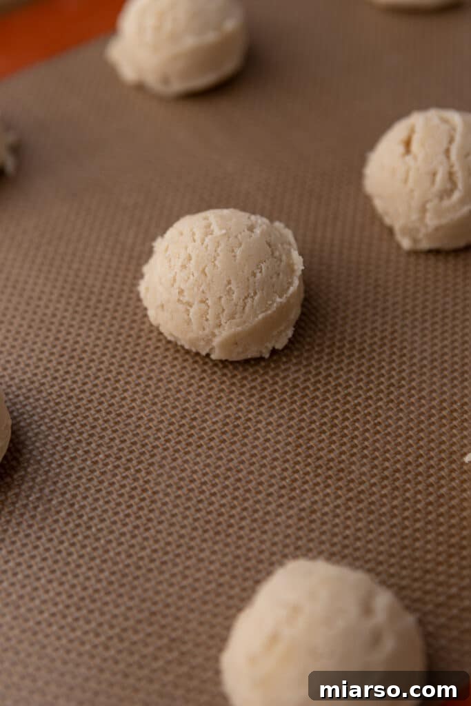 Ultimate Valentine Frosted Sugar Cookies 7 Scooped cookie dough balls on a parchment-lined baking sheet