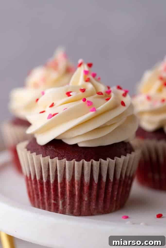 A single close-up of the small batch Red Velvet cupcakes, showcasing its vibrant red hue and creamy white frosting.