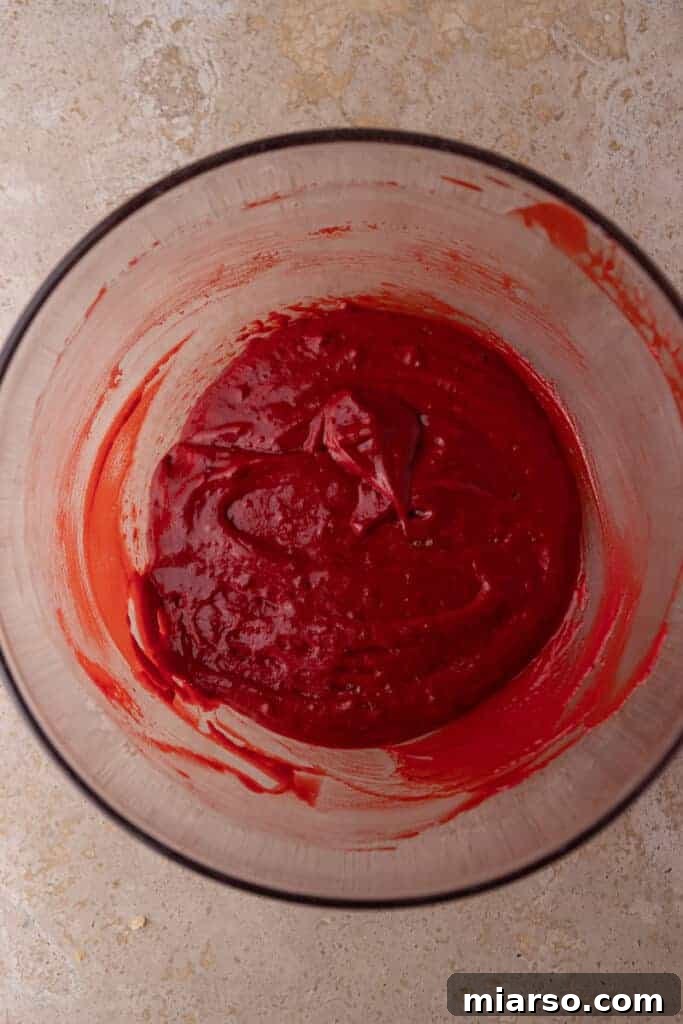 Fully mixed wet ingredients in a bowl, showcasing the vibrant red color of the batter.
