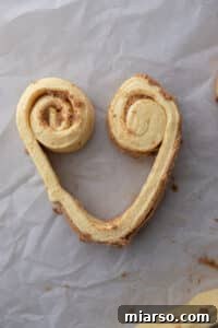 Valentines Sweetheart Cinnamon Buns Made Easy 16 Strip of dough partially rolled from each side to start forming the top curves of the heart.