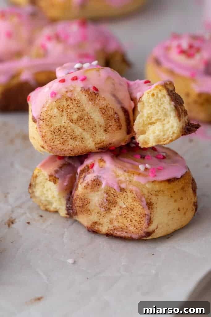 Valentines Sweetheart Cinnamon Buns Made Easy 4 Two freshly baked Valentine's Day heart-shaped cinnamon rolls, stacked elegantly, showcasing their fluffy texture and perfectly golden edges.